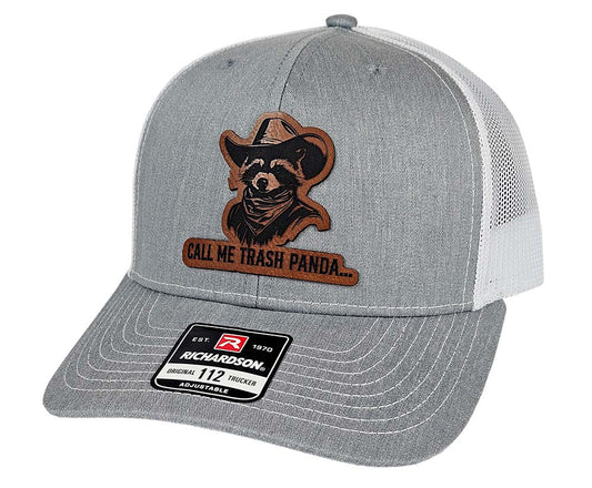 Gray and white mesh trucker hat with laser engraved western raccoon rawhide patch graphic and 'Call Me Trash Panda' text.